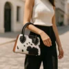 Edgy black cowhide leather bag featuring decorative metal studs and stylish design with comfortable handles for fashion-forward look