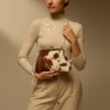 Elegant coral pink cowhide leather clutch purse featuring sleek modern design with secure zipper closure for evening events