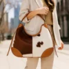 Crescent Moon Cowhide Hobo Bag 1 Stylish crescent moon shaped cowhide leather hobo bag in brown with elegant curved silhouette and comfortable shoulder strap